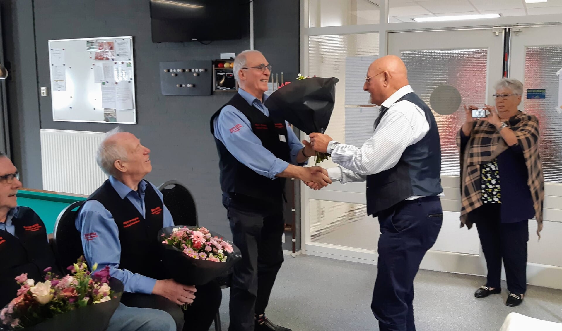 Arie van Eldik, Thijs van Schaik en Jan Beeren ontvangen felicitaties en bloemen van de erevoorzitter Peter van de Peppel. 