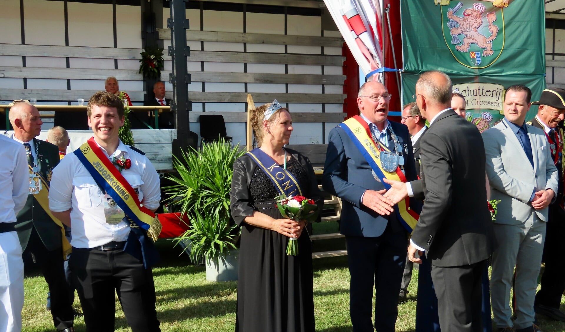 EMM Groessen-voorzitter John de Lorijn feliciteert het nieuwe Kringkoningspaar Jan Kelderman en Rita van Haren. Lars Som, de nieuwe jeugdkoning, kijkt lachend toe.