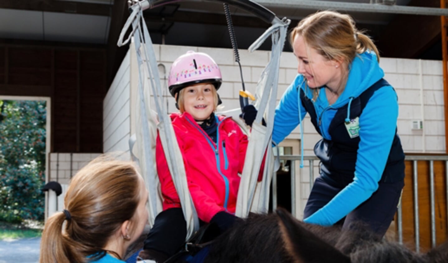 Ook gehandicapte kinderen kunnen dankzij speciale hulpmiddelen paardrijden.