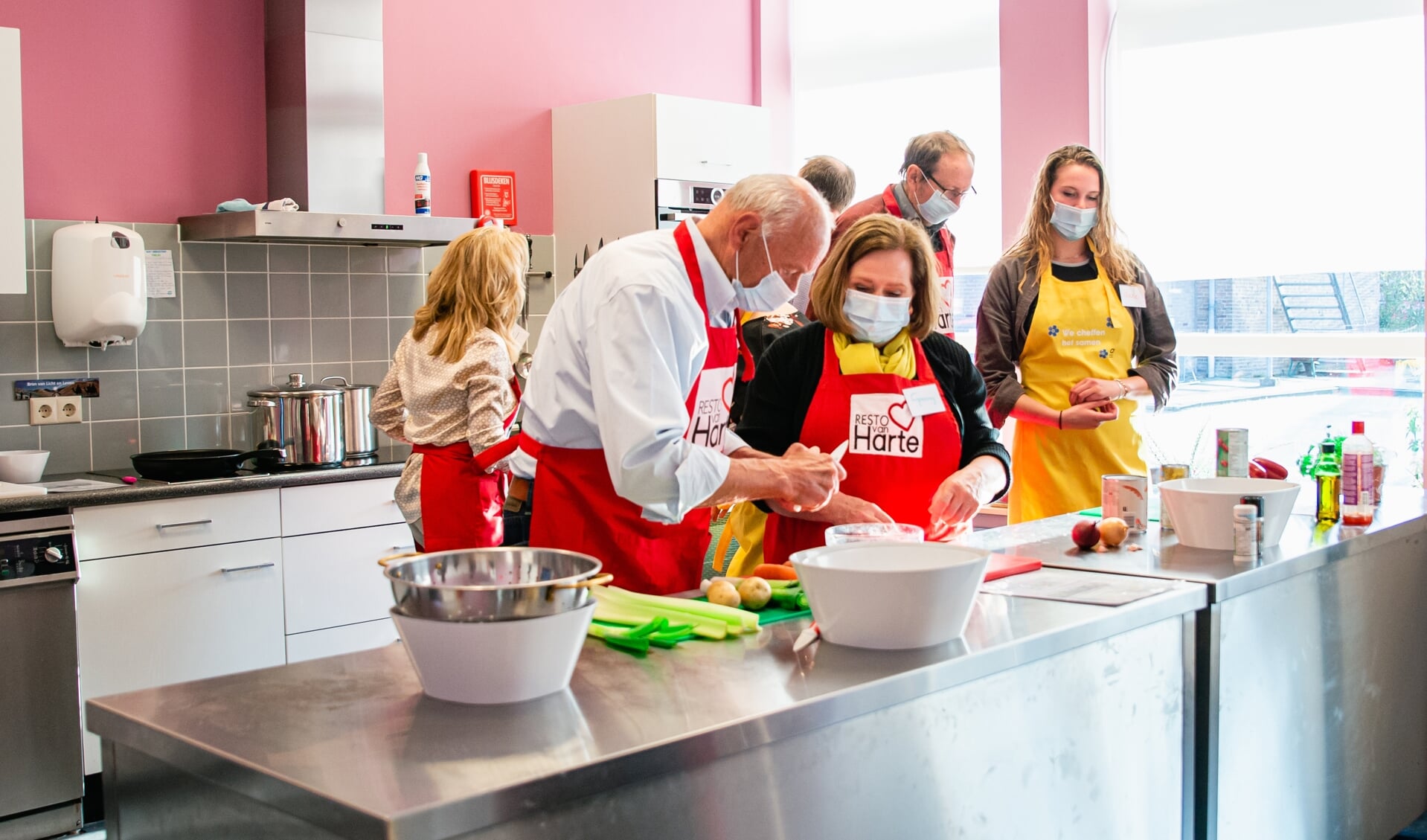 Deelnemers aan De Onvergetelijke Kookclub Elst bereiden het driegangen-diner. 