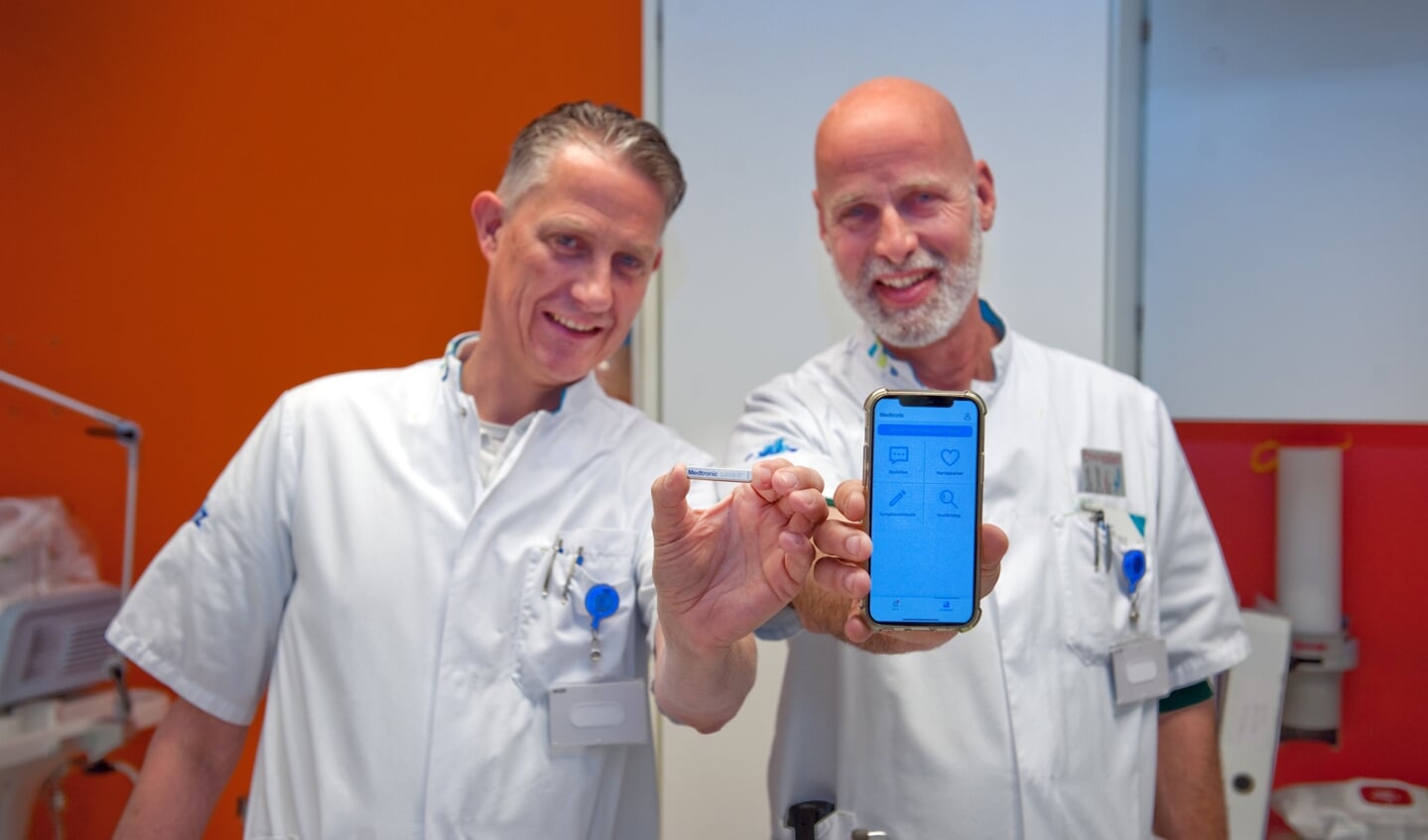 Cardioloog Erwin Zegers (links) en verpleegkundig specialist Jan Elders tonen de hartritmemonitor en de bijbehorende app. 