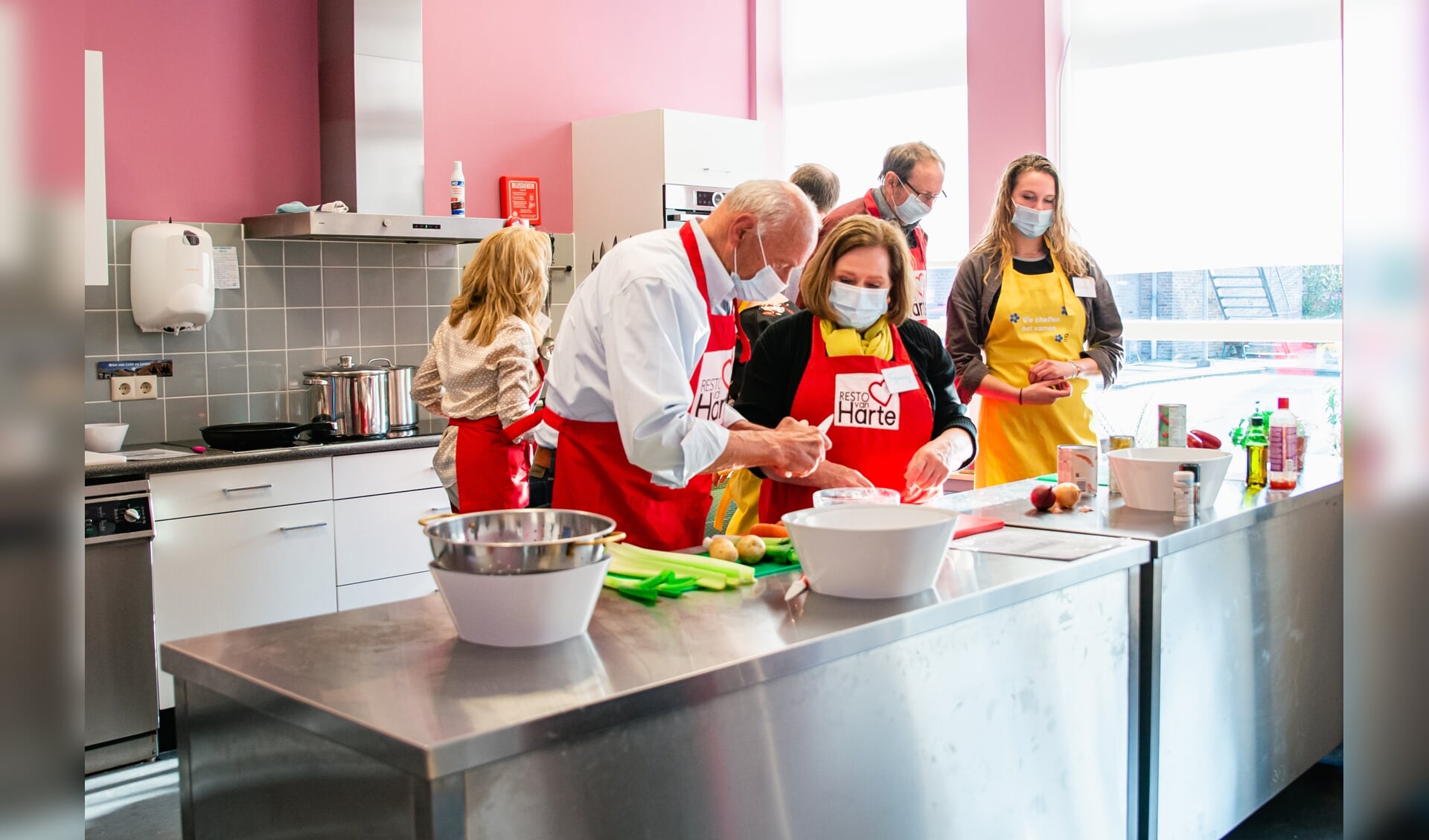 Deelnemers aan De Onvergetelijke Kookclub Elst bereiden het driegangen-diner. 