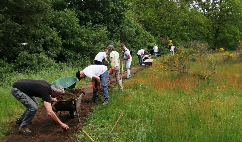 <p>Vrijwilligers van de Heemtuin leggen het familiepad aan.</p>