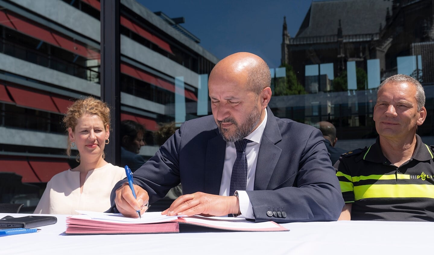 Ahmed Marcouch ondertekent het vierjarige veiligheidsarrangement. Links Jiskie Hollander van Arriva. (Foto: Rinus Baak)