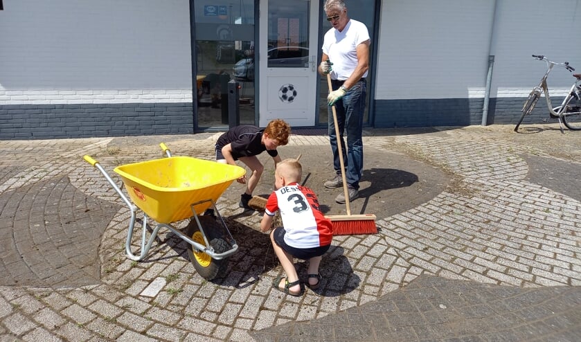 <p>Juca Zwartjes (7) en Mart van Kesteren helpen Eric van Ekelenburg een handje.</p>  