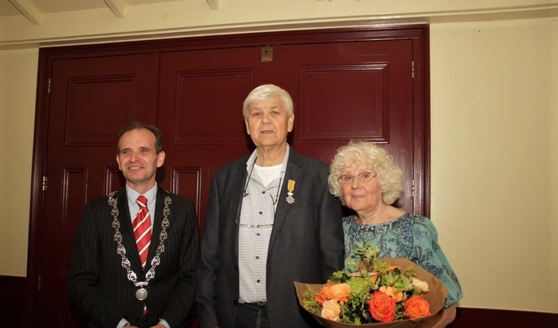De burgemeester samen met decorandus en echtgenote. 