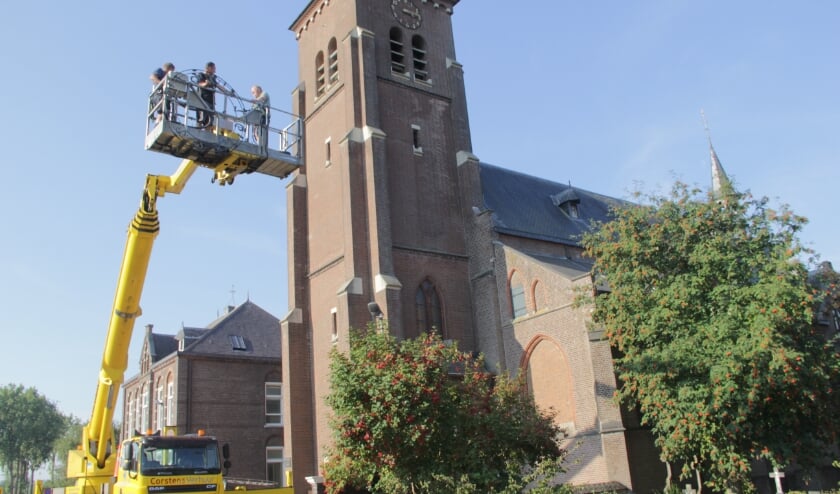 <p>Specialisten zij bezig de wijzerplaten te verwijderen van Sint-Hubertuskerk.</p>