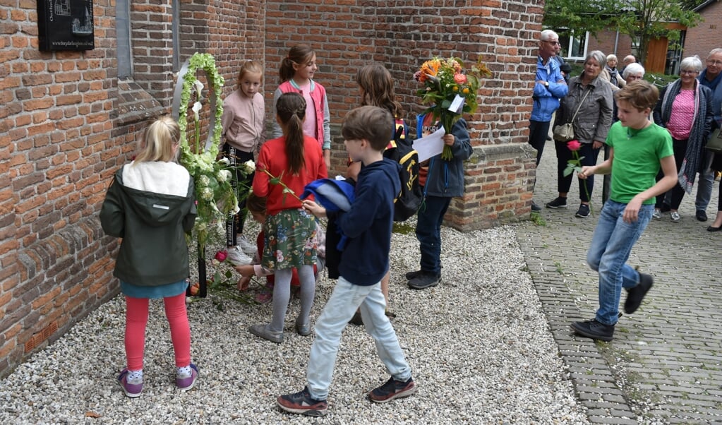 Kinderen van basisscholen De Lanteerne en De Zonnewende leggen bloemen bij het monument ter herinnering aan de Heese oorlogsdoden