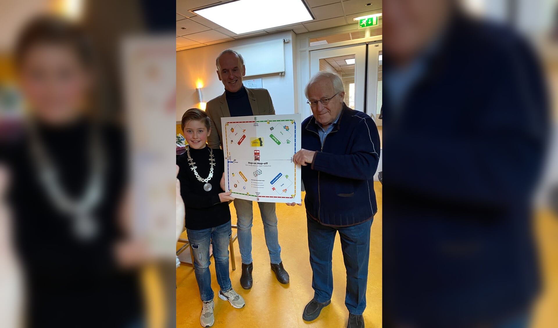 Marc Jansen met Thijmen, kinderburgemeester en Theo Voorn, coordinator huiskamer Oosterhout ontvangen het hop on hop off spel. (foto: Hester van Aalst)