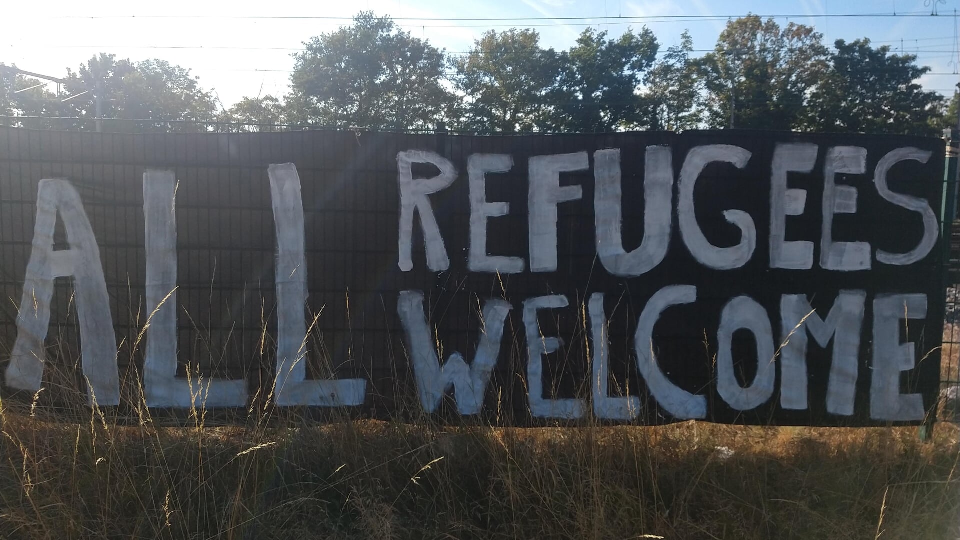 Spandoek langs de Spoorbrug in Nijmegen. 'Alle vluchtelingen welkom.'