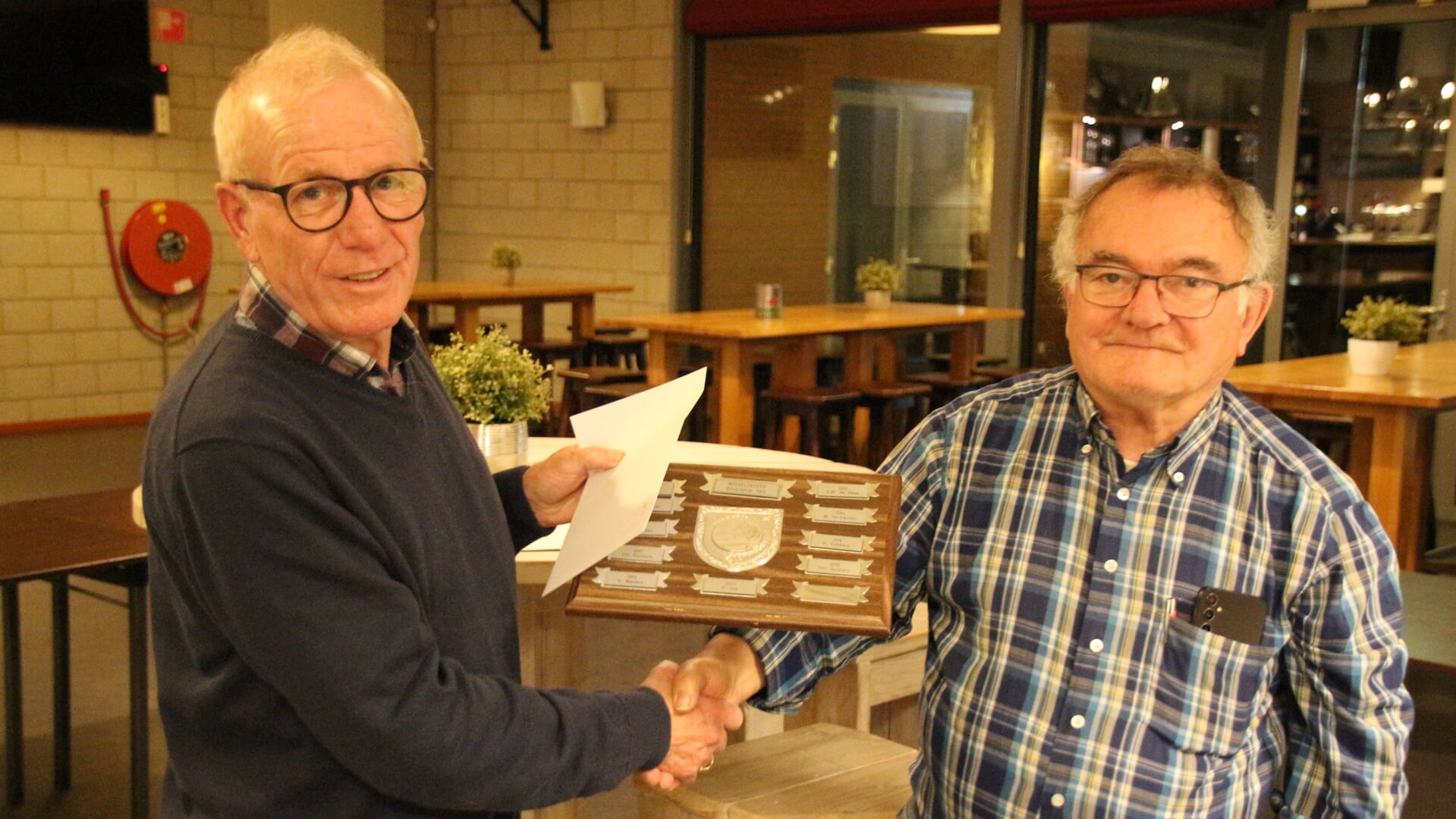 Sjaak Engelen ontvangt de wisselplaquette.