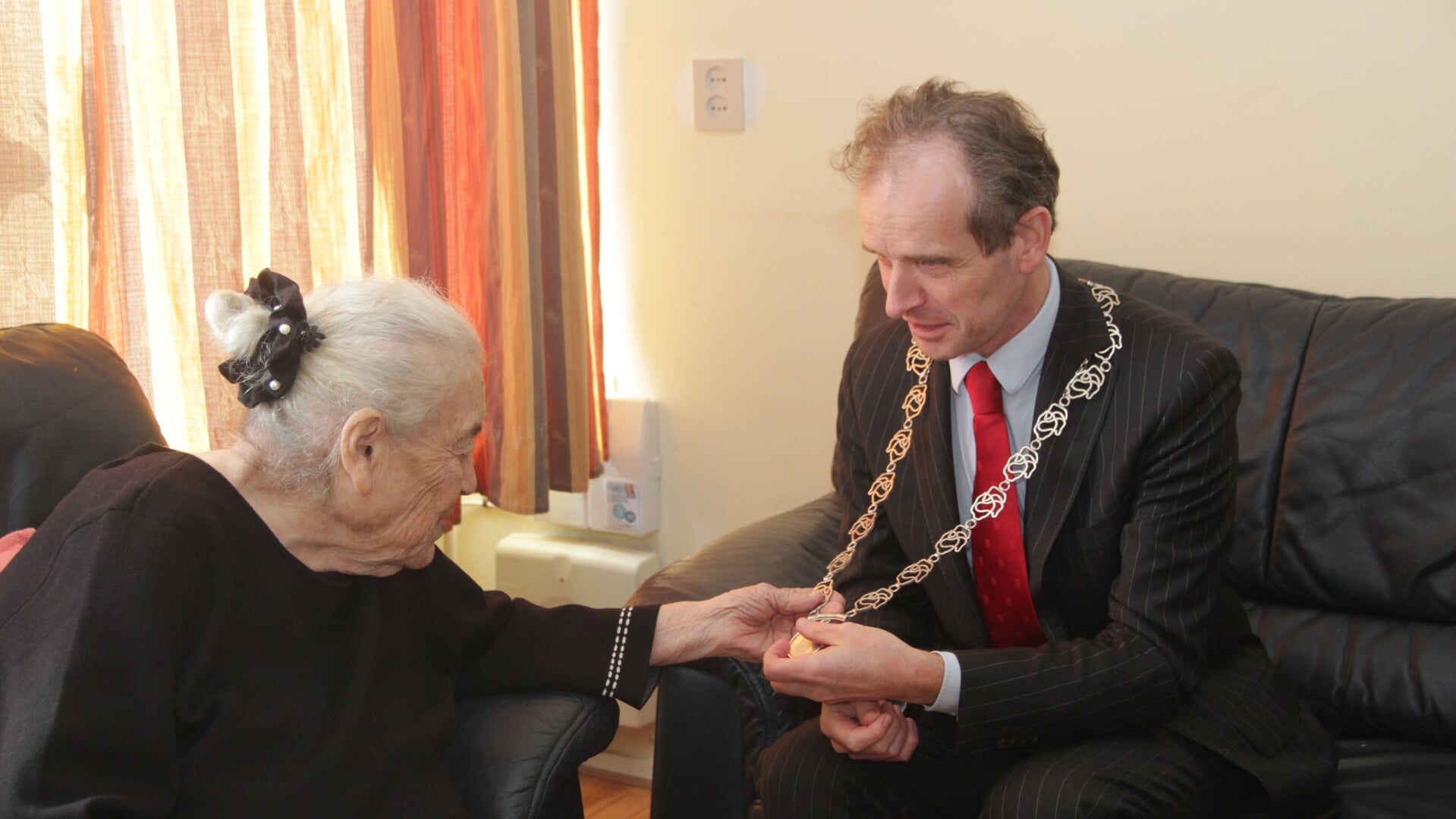 100-jarige mevrouw Danielian toont belangstelling voor de ambtsketen van de burgemeester. (foto: Peter Hendriks)