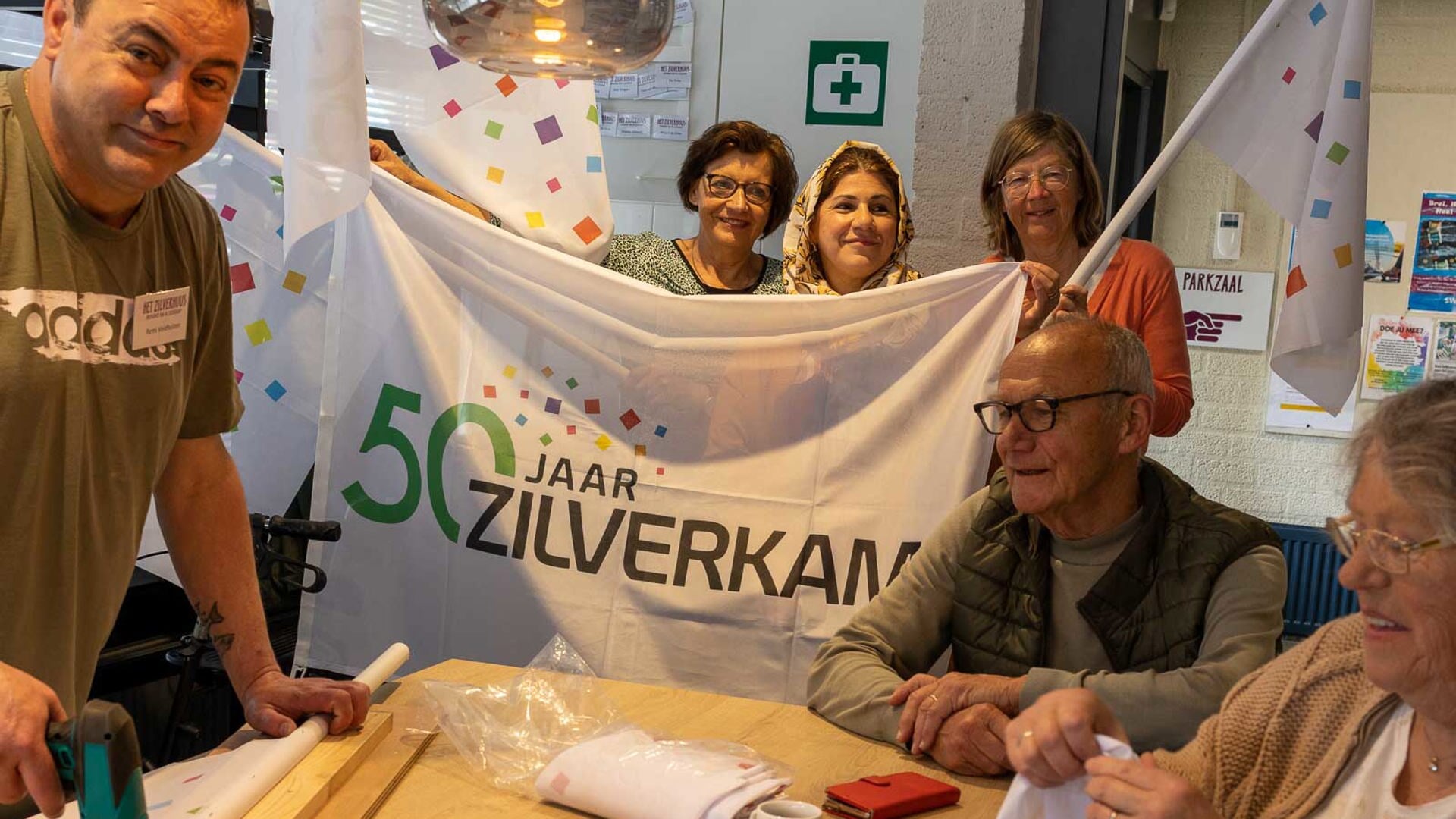 Inwoners van Zilverkamp maken de vlaggen voor hun jubilerende wijk.