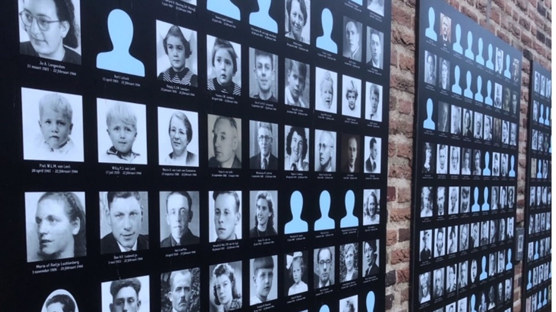 Een gedeelte van de fotowand aan de Emmaushof met de gezichten en namen van de slachtoffers van het bombardement.