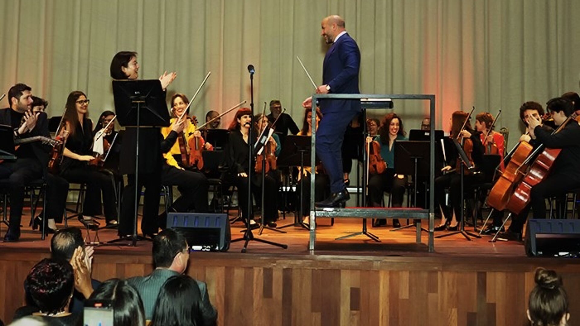 Burgemeester Marcouch even 'op de bok', links dirigent Kanako Abe.