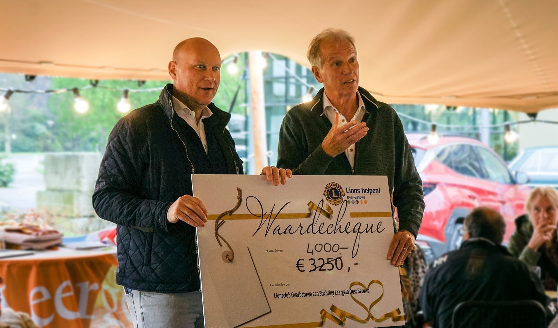 Cor Hendriks neemt cheque in ontvangst uitgereikt door Jan-Jaap Zollinger namens de Lions rally organisatie.
