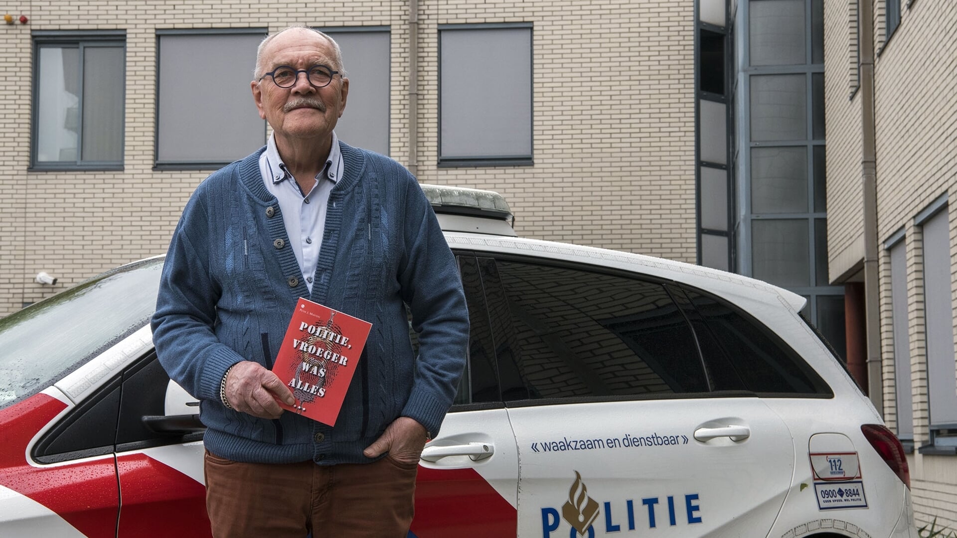 Peter Martens met in de hand zijn boek 'Politie, vroeger was alles...'. 