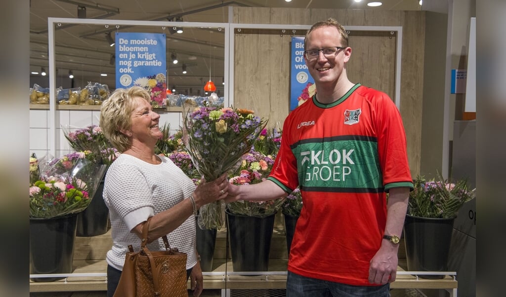 Lerrie Grooten geeft een voor hem onbekende vrouw een bosje bloemen. Zomaar een aardig gebaar. (Foto: Ellen Koelewijn Fotografie) 