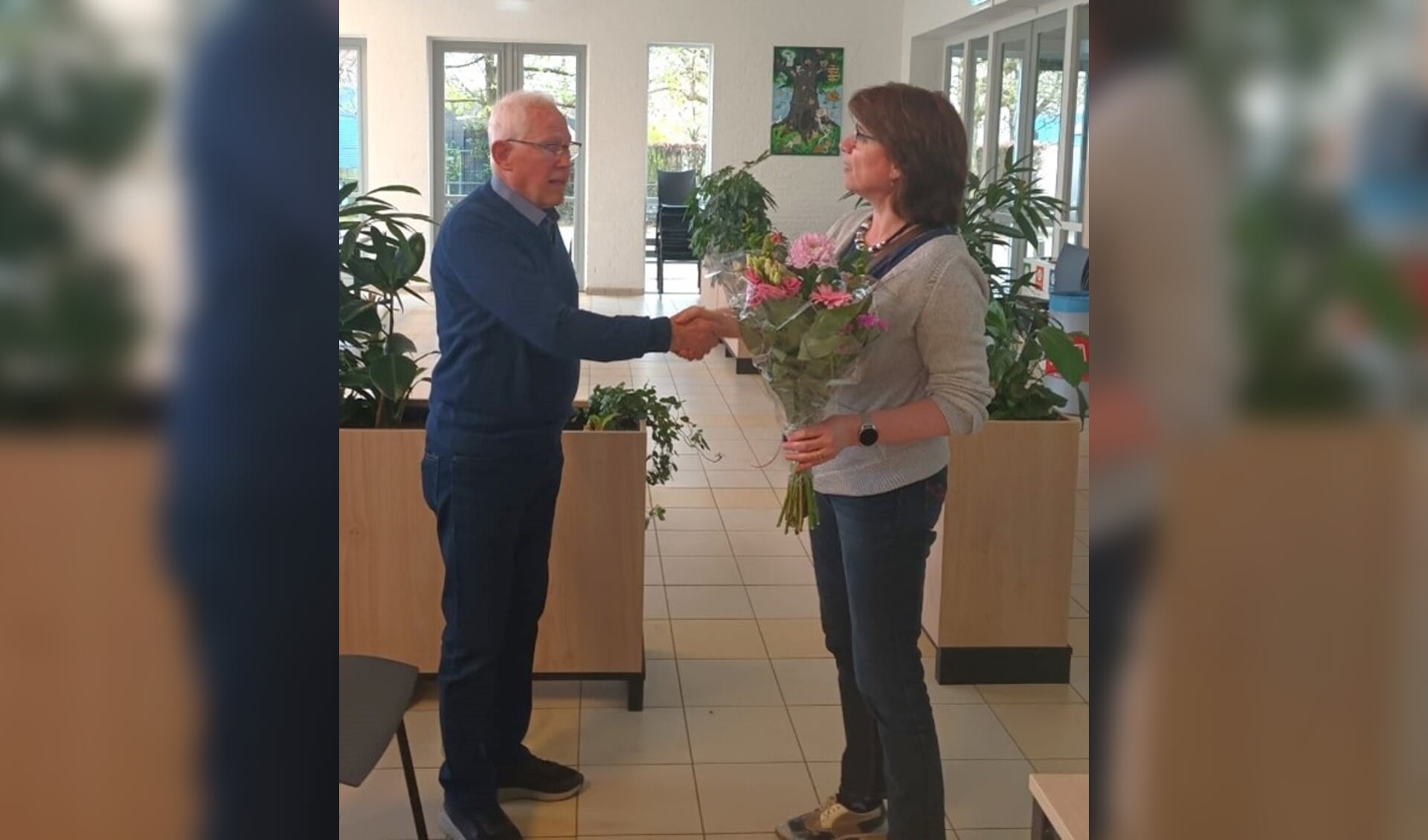 Hein Leenders ontvangt de felicitaties en bloemen van de voorzitter. 