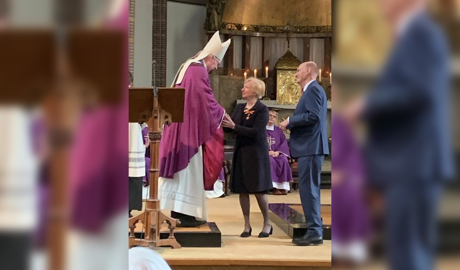 Maria Martens wordt door bisschop Gerard de Korte gefeliciteerd met de kerkelijke onderscheiding. 