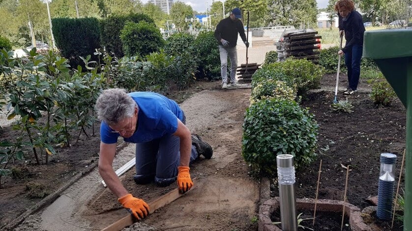 Flex-vrijwilligers verrichten een tuinklus. 