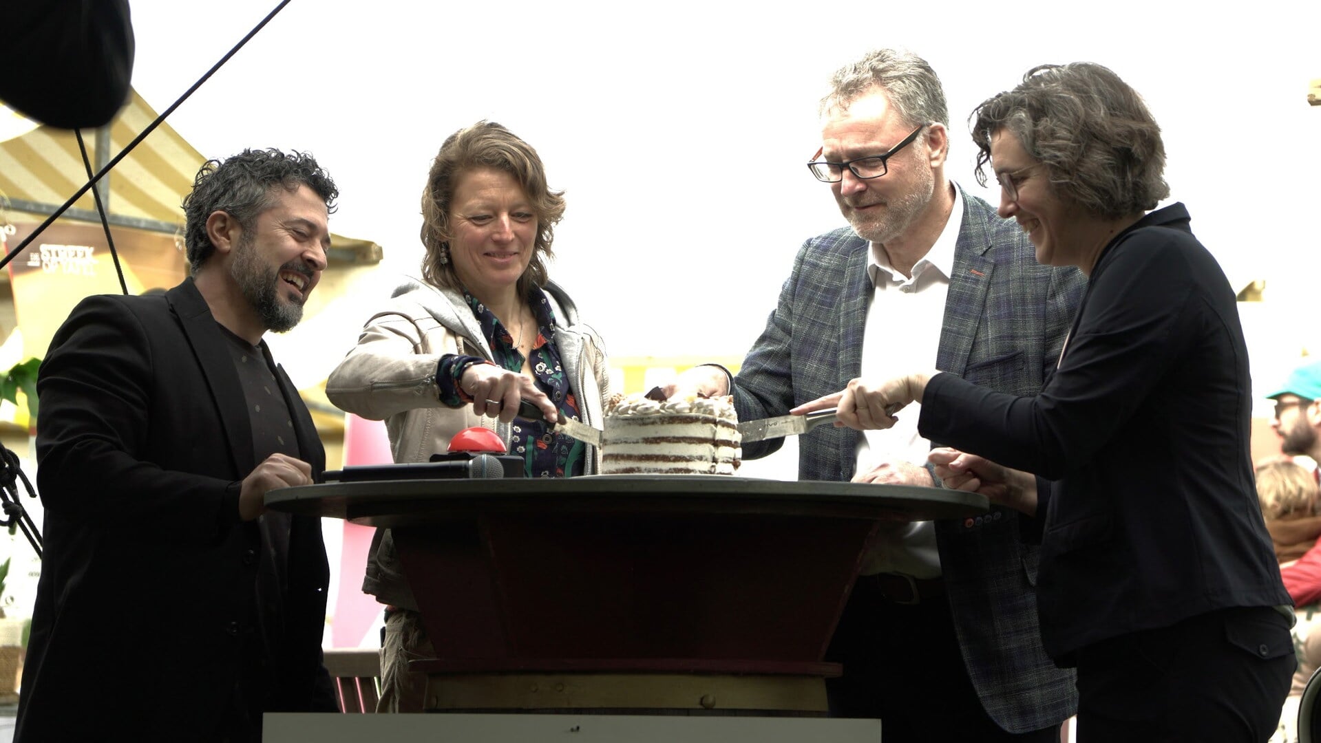 Wethouders Cilia Daemen (geheel rechts ) en Erik Weijers (tweede van rechts) snijden de taart aan.
