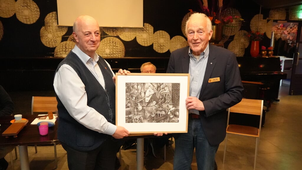 Voorzitter Jan Tuik van Rotaryclub Arnhem-Huissen doneert een pentekening aan Emile Smit, voorzitter van de Historische Kring Huessen. (foto: Foto Van Eimeren Huissen)