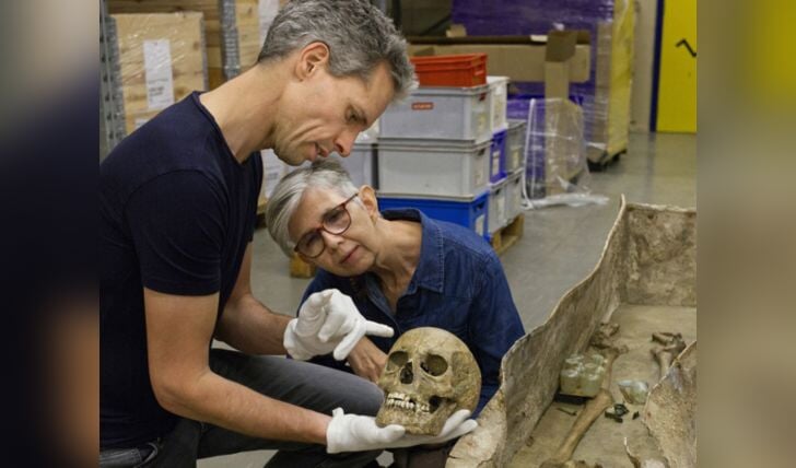 Archeologen Joep Hendriks en Katja Zee bekijken de schedel. Rechts de loden sarcofaag. 