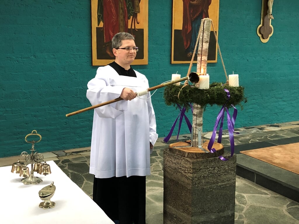 Koster Marcel van Grunsven steekt de eerste adventskaars aan. (foto: H. Antonius Abt Kerk Malden)