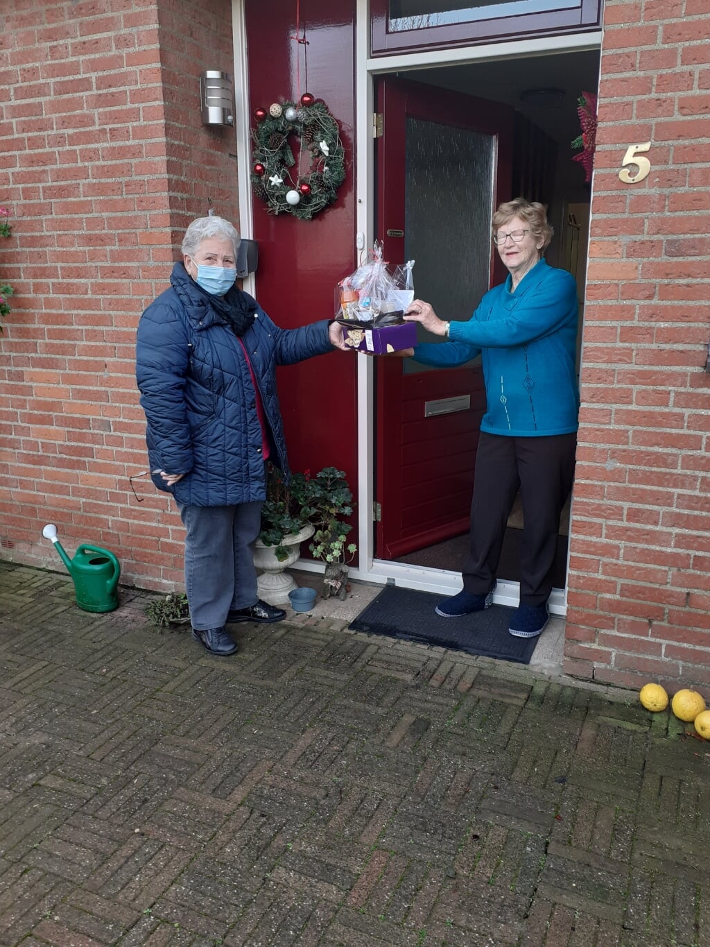 Jo Cornelissen brengt een kerstpakket bij een gast van de Zonnebloem. (foto: Stien op den Brouw)