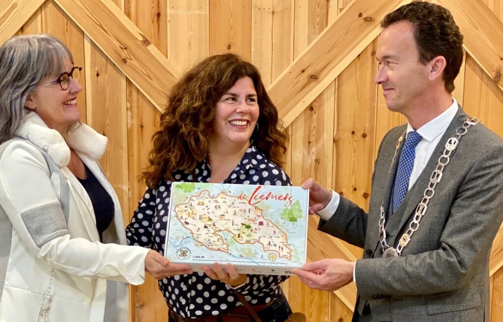 Marjan Span overhandigt de eerste puzzel aan burgemeester Lucien van Riswijk van Zevenaar