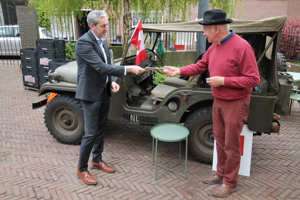 Roeland Janssen (met hoed) overhandigt Rhenens burgemeester Hans van der Pas het fietsrouteboekje. (foto: Marco Diepeveen)