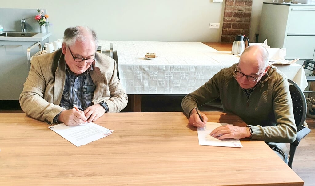 Huib Fienieg (links), bestuursvoorzitter stichting Zandse Kerk en Gerard Rikken (rechts), Bestuur stichting De Klup-Over Betuwe, ondertekenen beiden de huurovereenkomst. (foto: S. Bouwmeister)