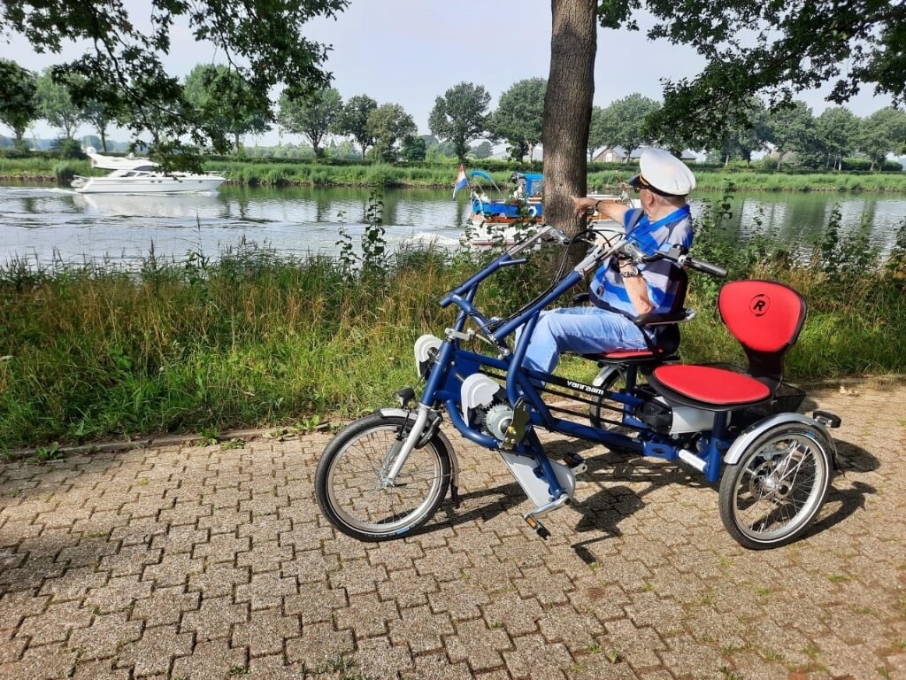 Een bewoner van Ouderenzorg Nijmegen maakt een uitstapje met de duofiets.