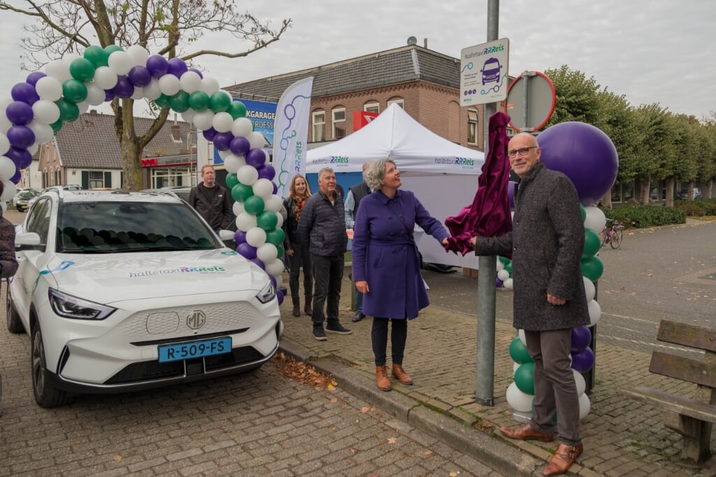 Wethouder Gemma Tiedink en Paul Pietersen onthullen het haltebord in Groessen. 