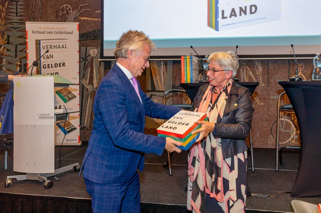 Dolly Verhoeven reikt het eerste exemplaar uit aan Commissaris van de Koning John Berends. (Bron: Provincie Gelderland, Rob Kleering)