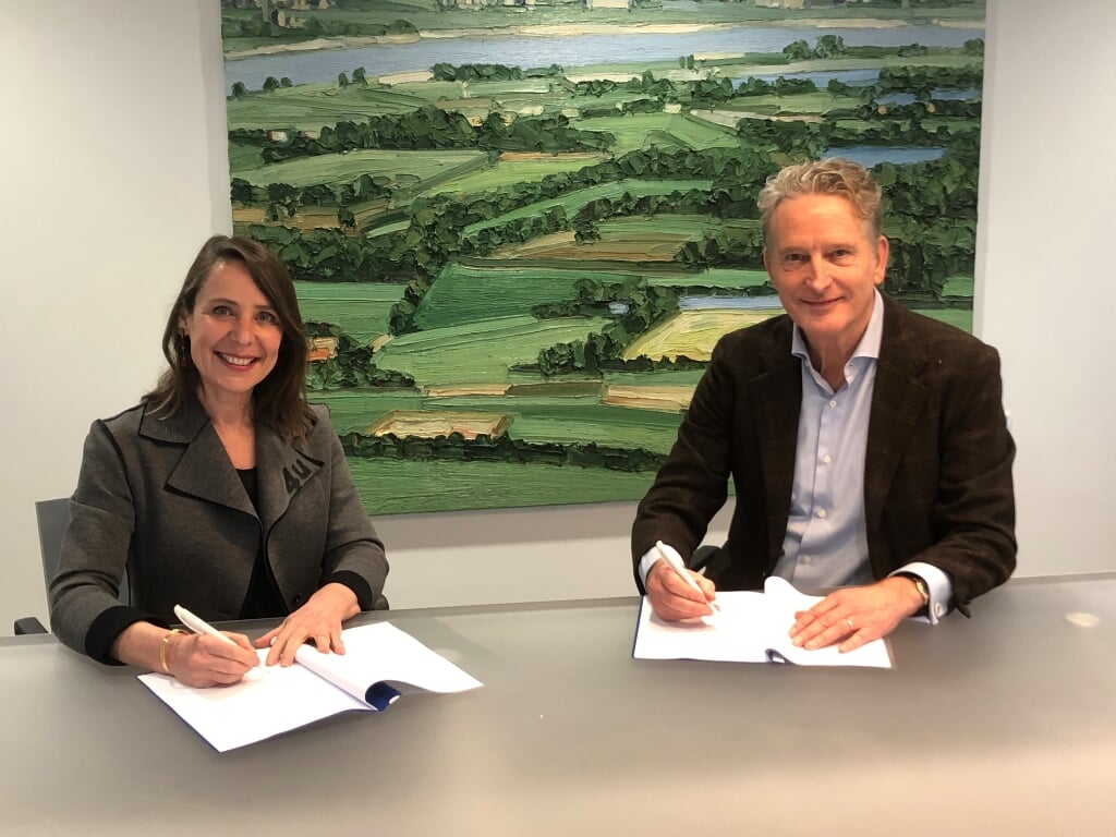 Jeanet van Antwerpen (l) van BPD en Cees van Boven van Woonzorg Nederland bij de ondertekening.