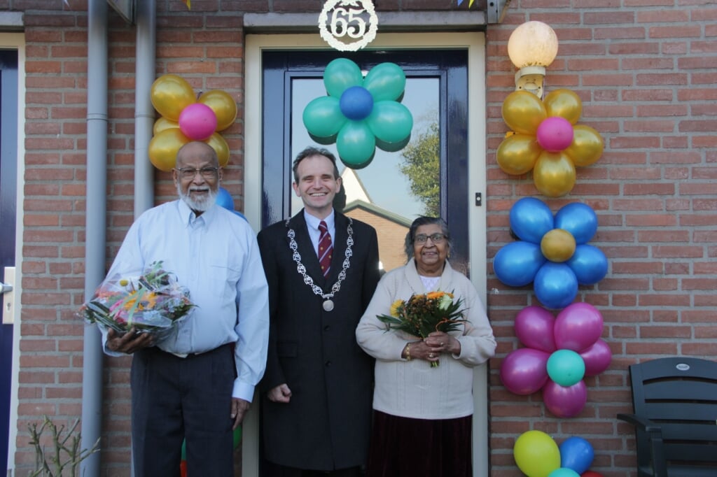 Burgemeester Slinkman feliciteert het briljanten paar met een fraai bloemstuk. (foto: Peter Hendriks)