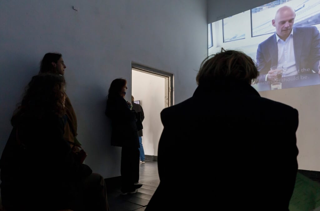 Bezoekers kijken naar de documentaire ‘Tussen Blauwe Golven en Groene Corridor’ van Hans van Houwelingen & ArtezTeam. (Foto: Django van Ardenne)  