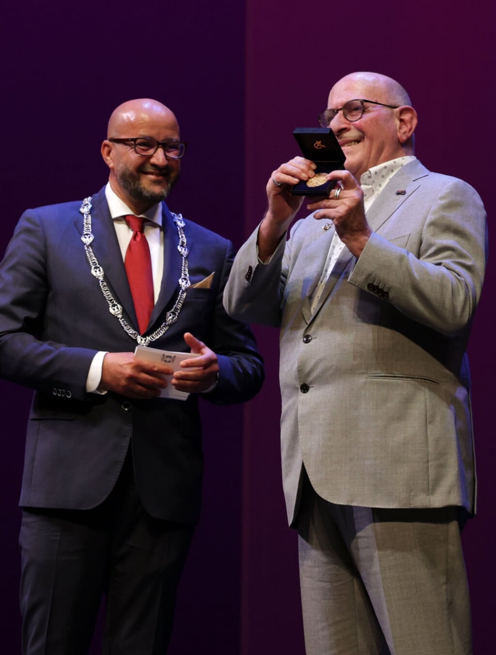 Burgemeester Marcouch speldt Ton Wiggers  de Gouden Stadspenning op.