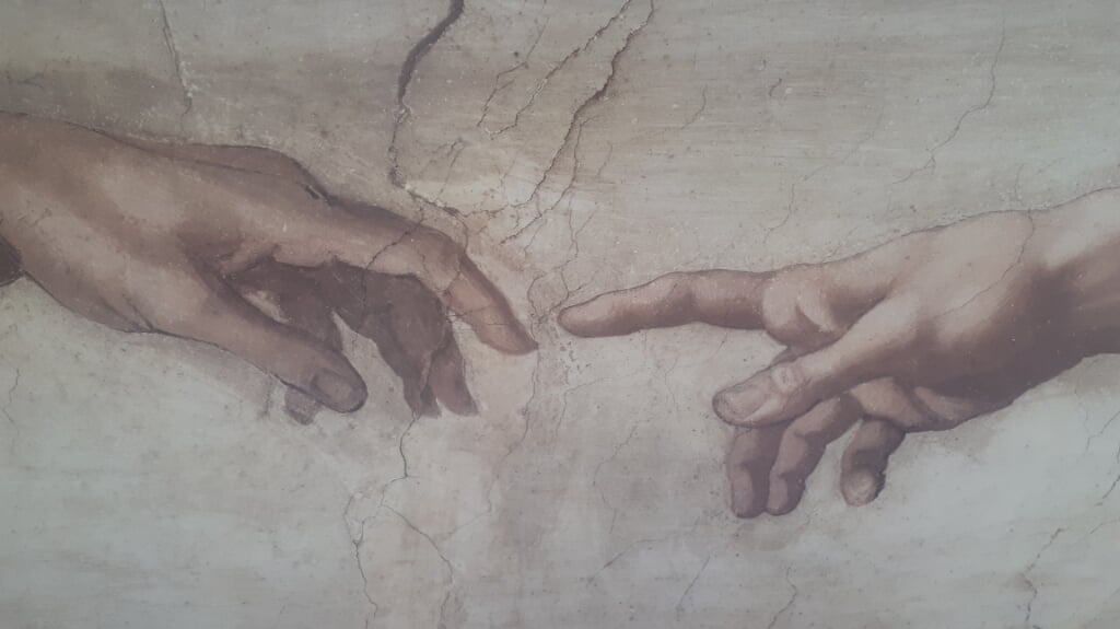 uitsnede van schilderij van Michelangelo: de schepping van Adam