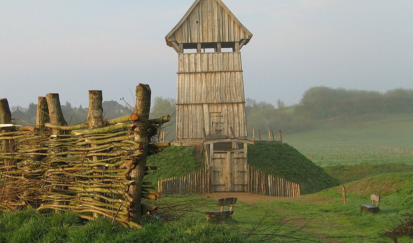 Voorbeeld van een motteburcht. Een hoger gelegen gedeelte met daarop een houten toren en op het lagere deel een boerderij of kleine woongemeenschap.