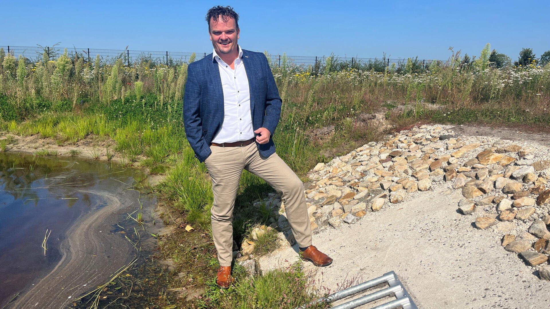 De wethouder, bij een zogeheten overstort van het regenwaterriool op bedrijventerrein Oosterweilanden in Vriezenveen.