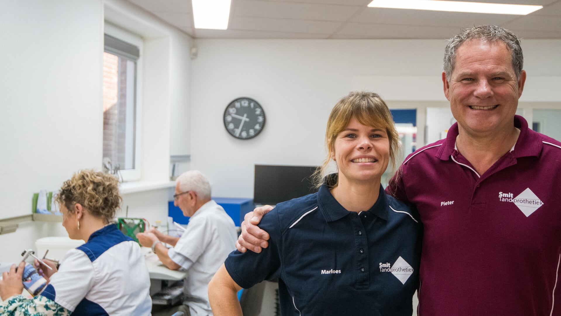 Marloes en Pieter Smit met op de achtergrond het team van Smit Tandprothetiek.