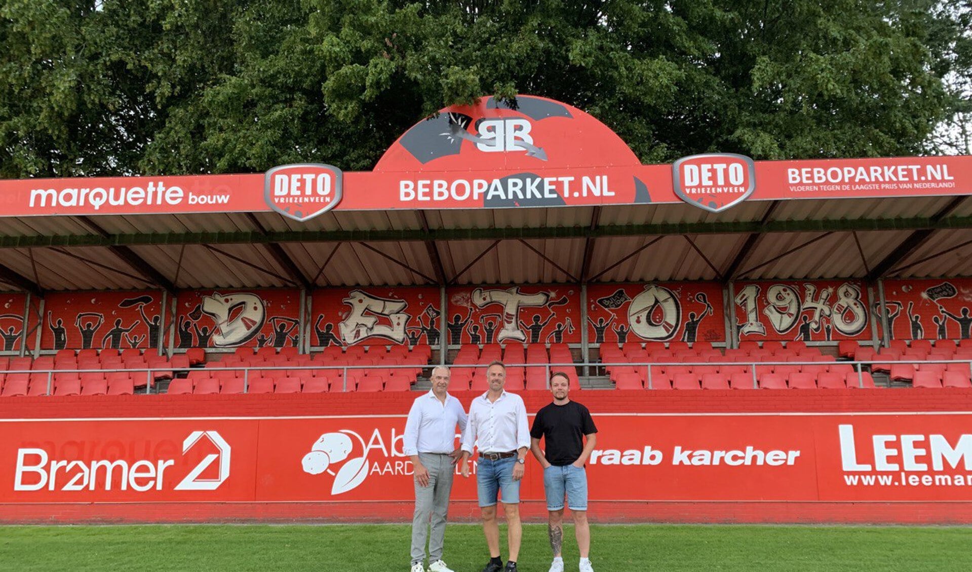 Harald Rohof (voorzitter supportersvereniging), Derby Krommendijk (voorzitter DETO) en Ted Duursma (skik.an) voor het graffiti-kunstwerk.