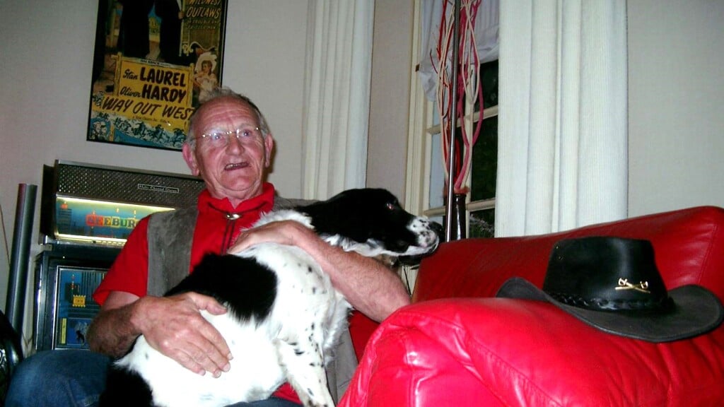 Harm Agteresch in zijn woonkamer in 2007. Zijn westernhoed op de leuning en heidewachtel Belabberd op schoot. 